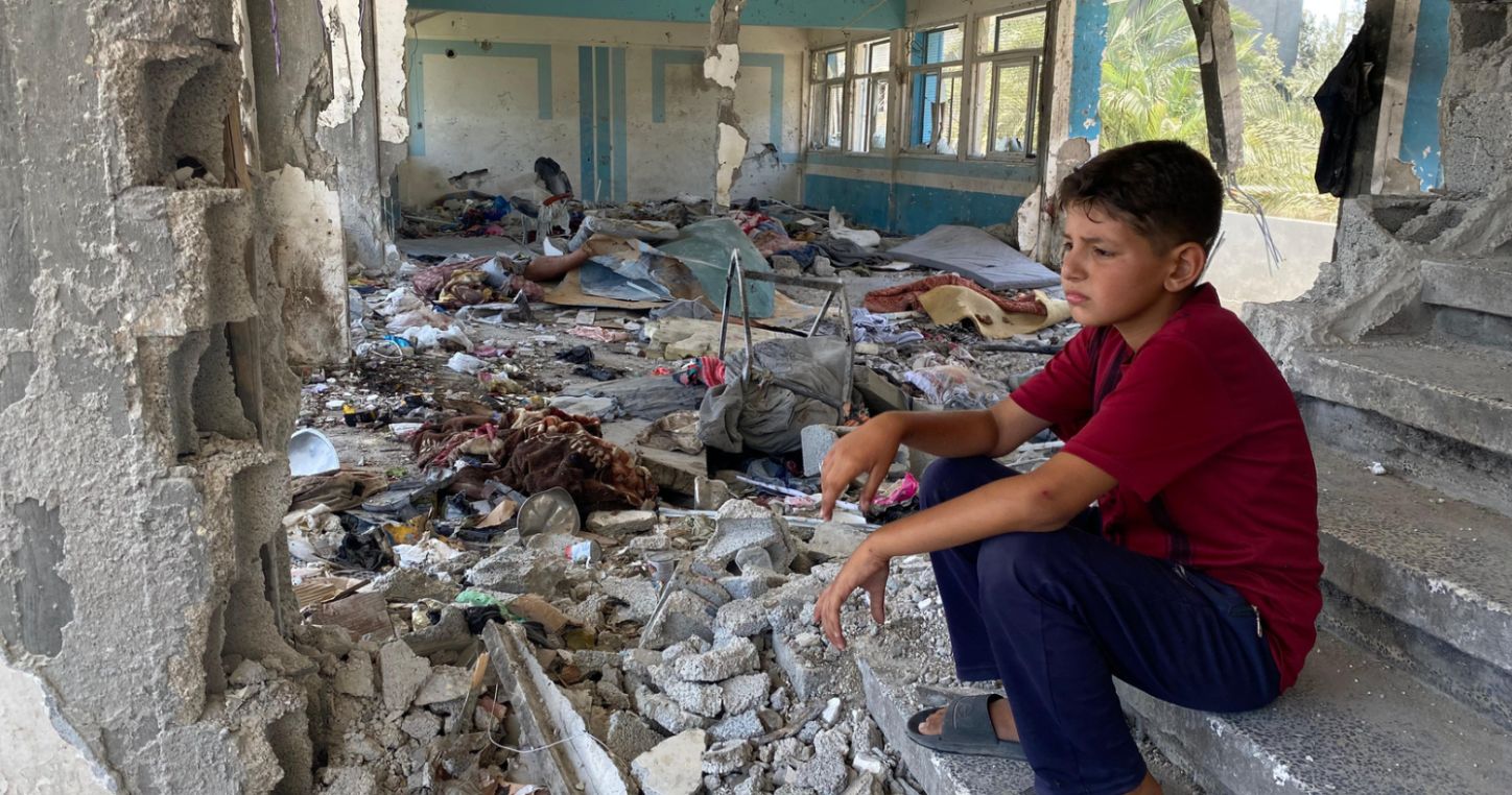 Boy sitting in the rubble of a destroyed UNRWA school in Nuseirat, in the Gaza Strip. © 2024 UNRWA Photo